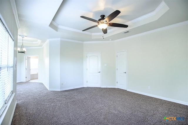 spare room featuring carpet floors, a raised ceiling, visible vents, and ornamental molding