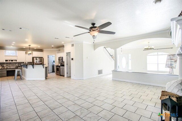 dining area with arched walkways, visible vents, stairs, ornamental molding, and ornate columns