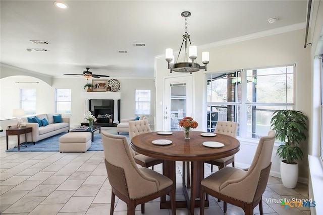 dining room featuring ornamental molding, arched walkways, and visible vents