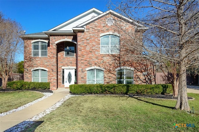 view of front of house featuring brick siding and a front yard