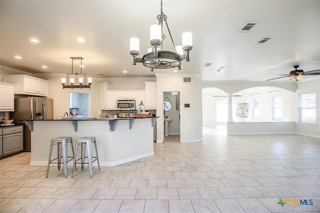 kitchen with visible vents, white cabinets, dark countertops, appliances with stainless steel finishes, and open floor plan