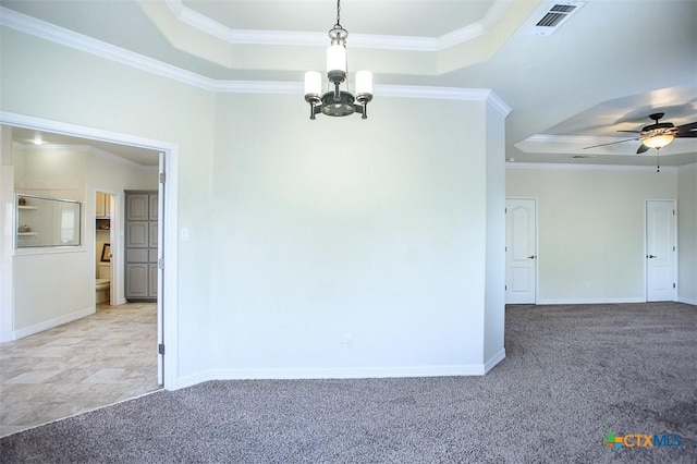 spare room with visible vents, a tray ceiling, ornamental molding, and light colored carpet