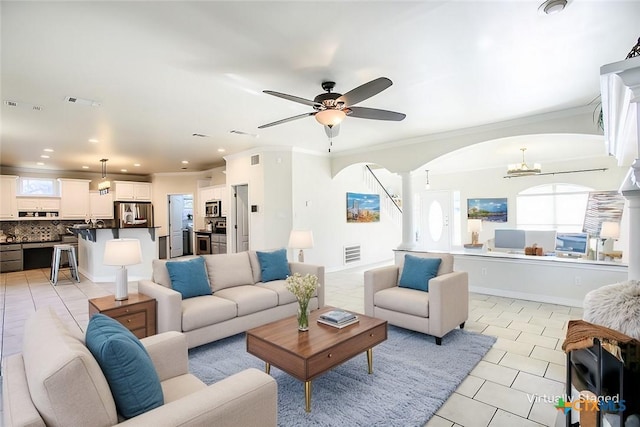 living area with ornamental molding, arched walkways, visible vents, and light tile patterned floors