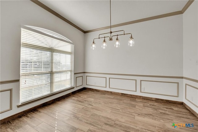 unfurnished dining area with light wood-type flooring, ornamental molding, and vaulted ceiling