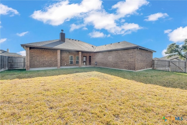 rear view of property with a lawn