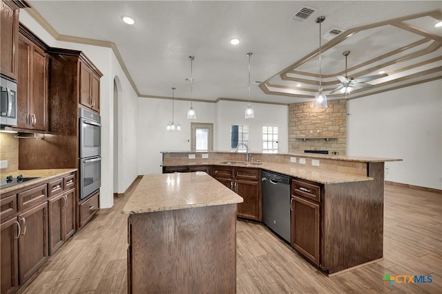 kitchen with pendant lighting, a large island, ornamental molding, and appliances with stainless steel finishes