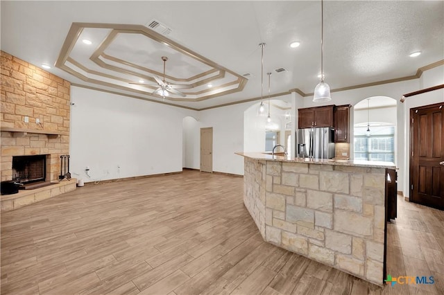 kitchen featuring ceiling fan, stainless steel fridge, crown molding, pendant lighting, and a tray ceiling