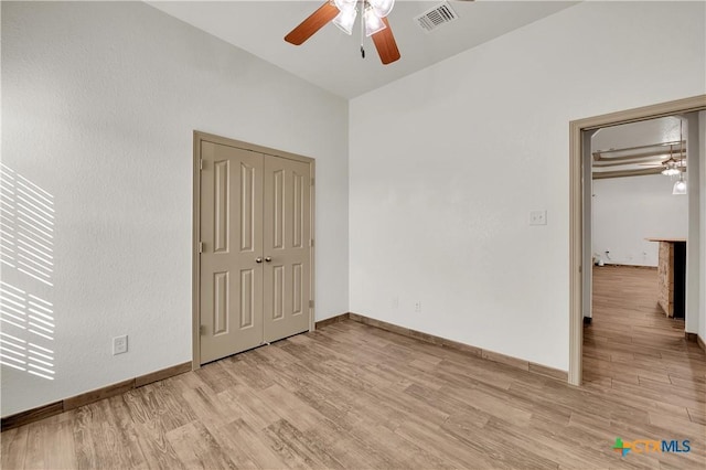 unfurnished bedroom with ceiling fan, a closet, and light wood-type flooring