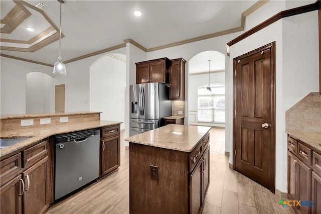 kitchen featuring light stone countertops, appliances with stainless steel finishes, a center island, and pendant lighting