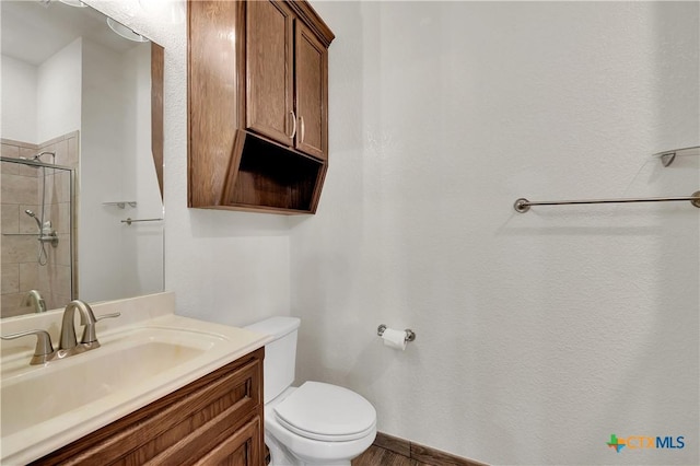 bathroom with vanity, a shower with shower door, and toilet