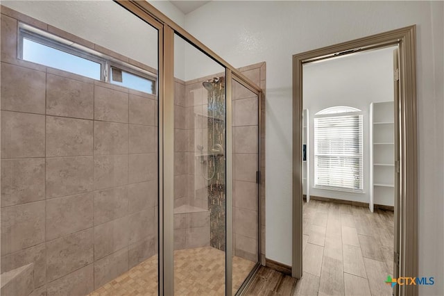 bathroom featuring hardwood / wood-style floors and a shower with door