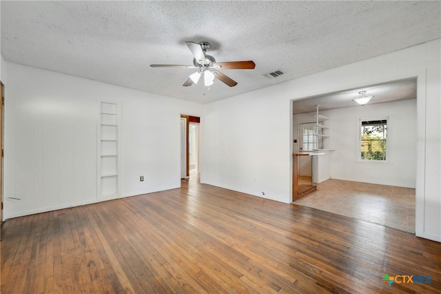 unfurnished room featuring ceiling fan, hardwood / wood-style floors, and a textured ceiling