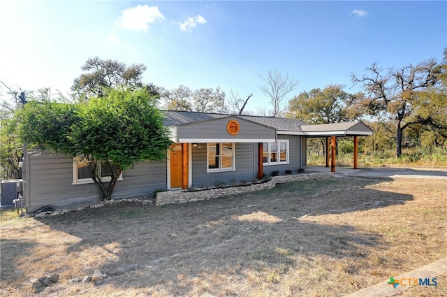 ranch-style home with a carport and cooling unit