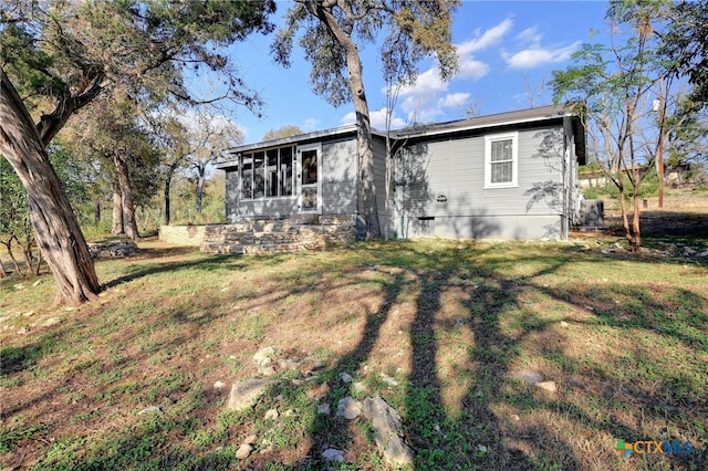 back of property with a sunroom and a yard