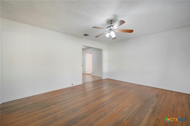 spare room with a textured ceiling, ceiling fan, and dark wood-type flooring