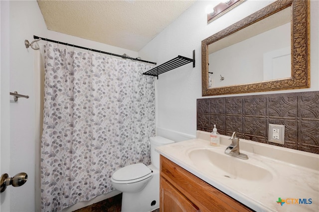 bathroom with vanity, a textured ceiling, and toilet