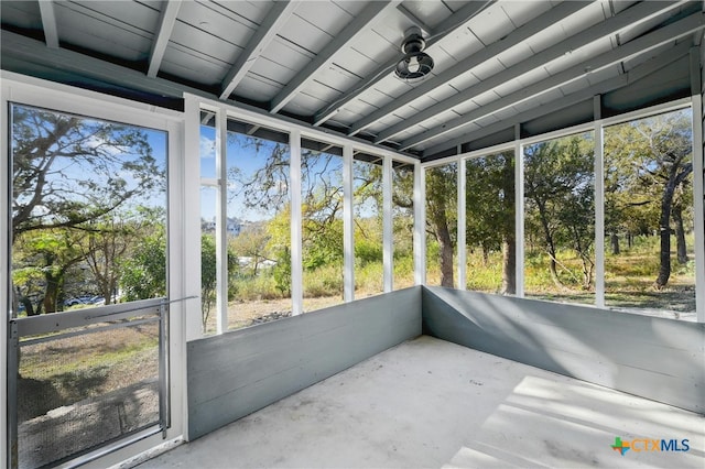 sunroom / solarium featuring vaulted ceiling with beams