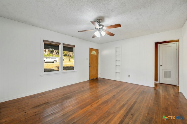 empty room with dark hardwood / wood-style flooring and a textured ceiling