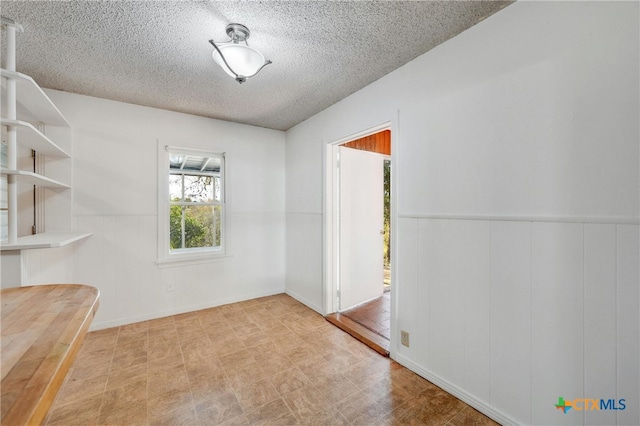 unfurnished room with a textured ceiling