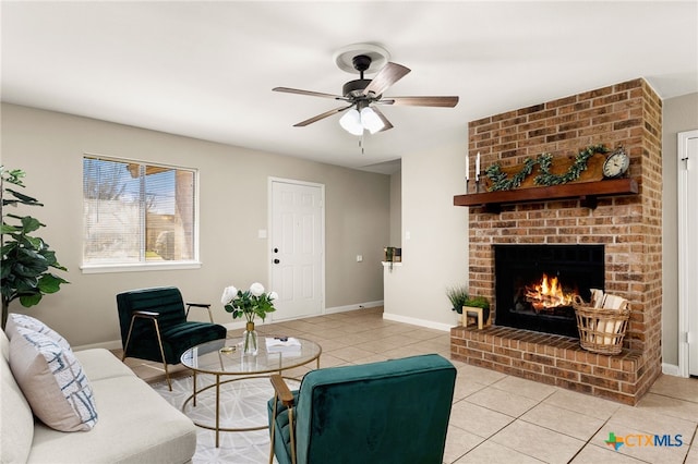 living room with a ceiling fan, a fireplace, baseboards, and light tile patterned floors