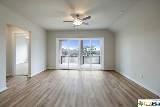 empty room featuring light hardwood / wood-style floors, ceiling fan, and vaulted ceiling