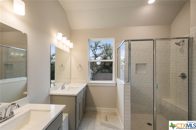 bathroom with a shower with shower door, vanity, and vaulted ceiling