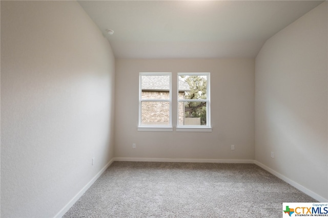 unfurnished room featuring carpet flooring and vaulted ceiling