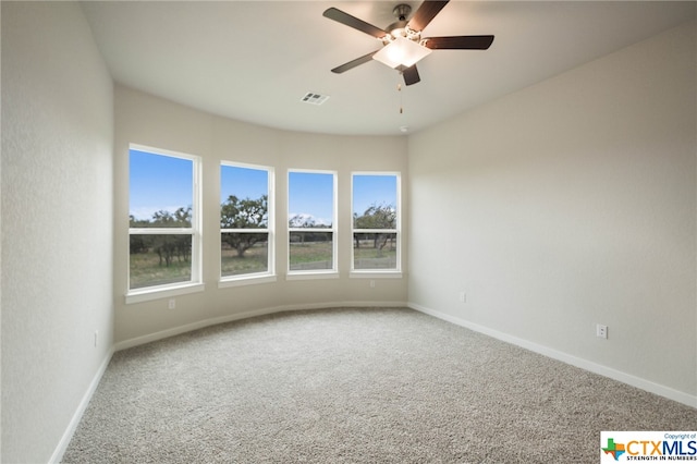 unfurnished room with ceiling fan and carpet