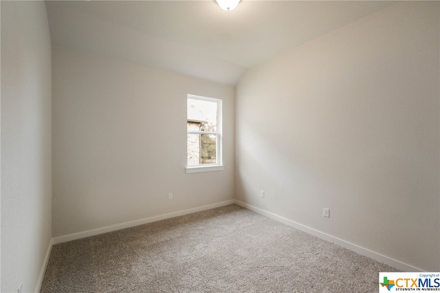 spare room featuring lofted ceiling and carpet floors