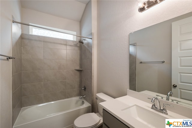 full bathroom featuring vanity, tiled shower / bath combo, and toilet