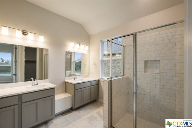 bathroom featuring walk in shower, lofted ceiling, a healthy amount of sunlight, and vanity