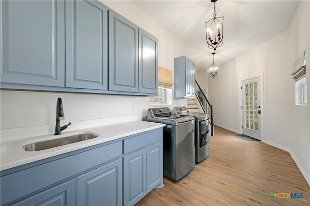1660 W Mccarty Ln, San Marcos, TX 78666 - washroom featuring washer and clothes dryer, cabinet space, light wood-style flooring, and baseboards