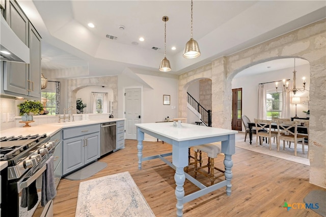 1660 W Mccarty Ln, San Marcos, TX 78666 - kitchen with stainless steel appliances, gray cabinets, arched walkways, light wood finished floors, and a sink