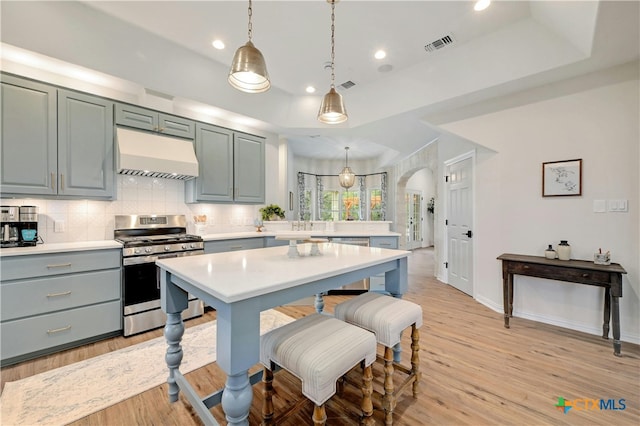 1660 W Mccarty Ln, San Marcos, TX 78666 - kitchen featuring appliances with stainless steel finishes, extractor fan, arched walkways, light countertops, and backsplash