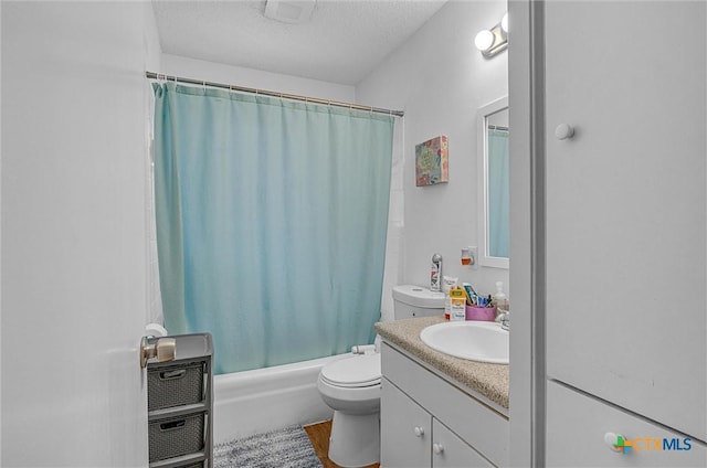 full bathroom featuring vanity, shower / bath combination with curtain, toilet, and a textured ceiling