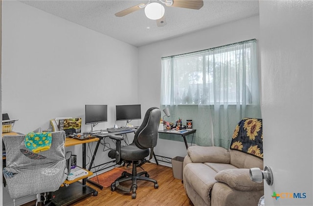 office area featuring hardwood / wood-style floors, a textured ceiling, a baseboard radiator, and ceiling fan