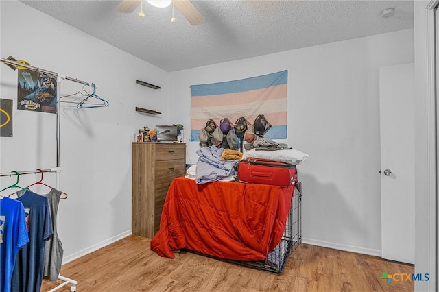 bedroom featuring hardwood / wood-style floors, a textured ceiling, and ceiling fan