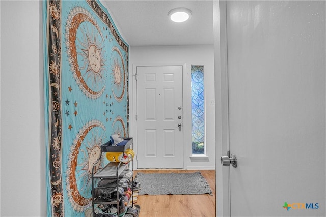 entrance foyer with hardwood / wood-style floors and a textured ceiling