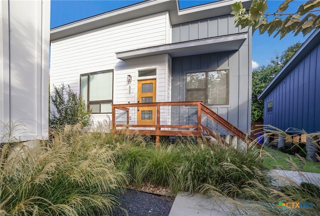 view of exterior entry featuring a wooden deck