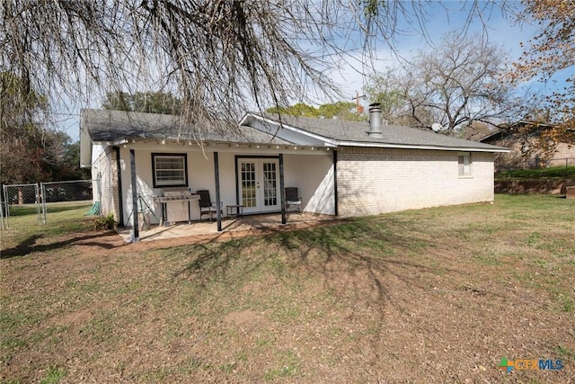 rear view of property featuring french doors, a yard, and a patio