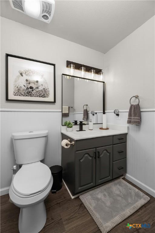 bathroom featuring toilet, wood-type flooring, and vanity