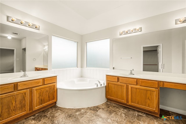 bathroom with a washtub and vanity