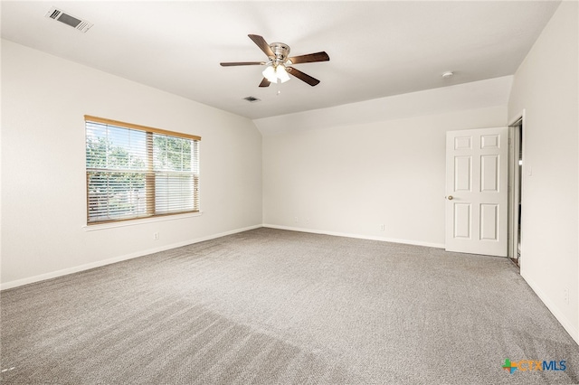 carpeted spare room featuring ceiling fan and vaulted ceiling