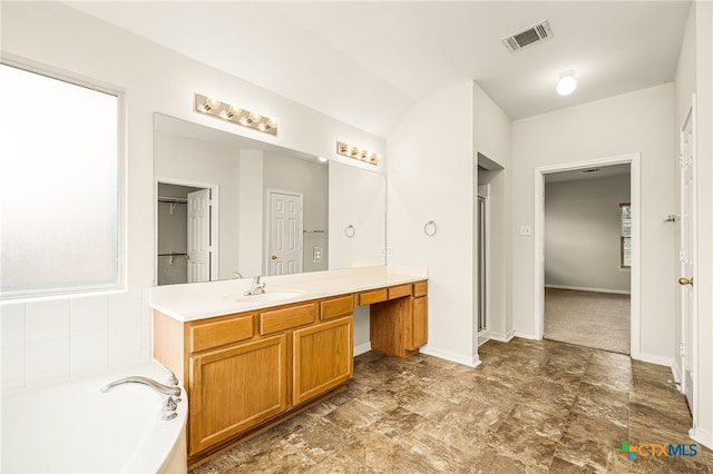 bathroom with a tub to relax in and vanity