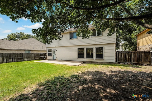 rear view of property featuring a yard and a patio