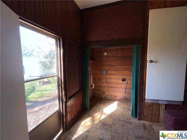 hallway featuring wood walls