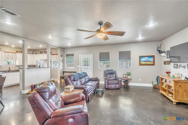 living room with a textured ceiling and ceiling fan