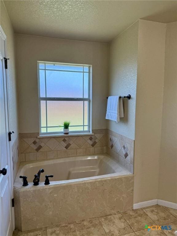 3508 Lucas St, Copperas Cove, TX 76522 - bathroom with a textured ceiling, a bath, and tile patterned floors