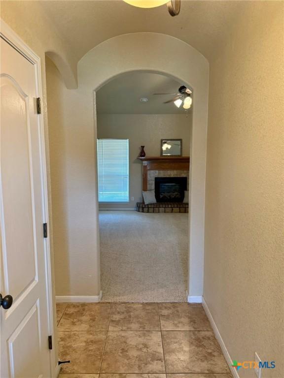 3508 Lucas St, Copperas Cove, TX 76522 - hall featuring arched walkways, light tile patterned floors, light carpet, baseboards, and a textured wall