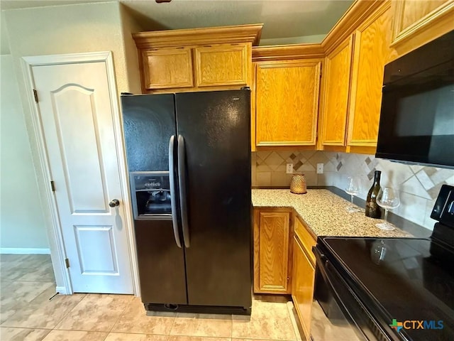 3508 Lucas St, Copperas Cove, TX 76522 - kitchen with black appliances, backsplash, brown cabinets, and light stone countertops